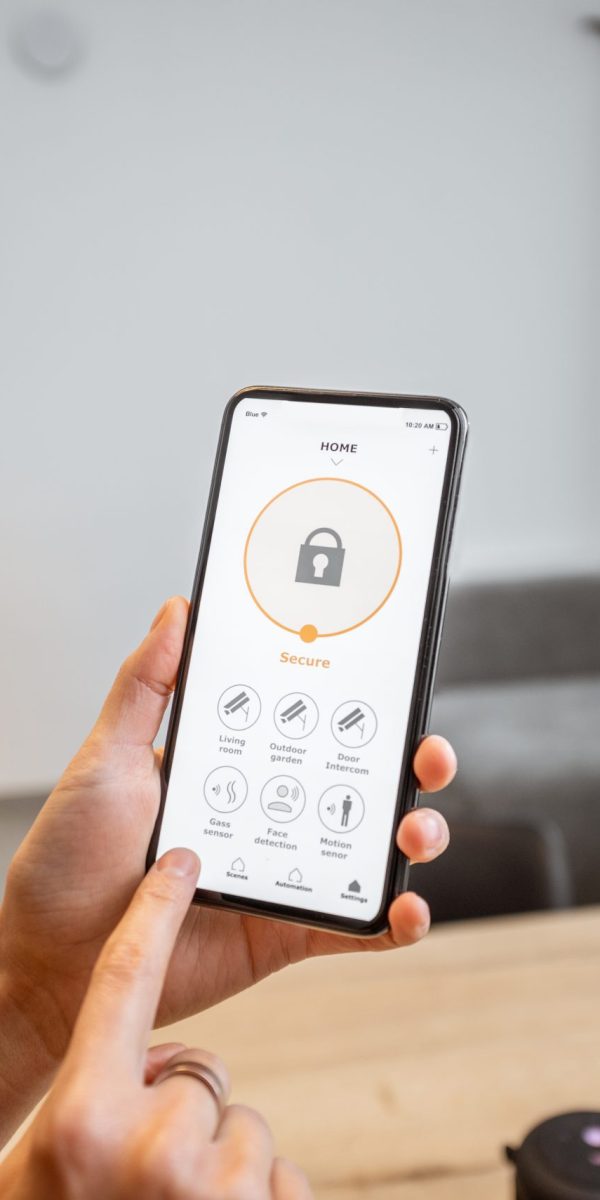 Smartphone with security application indoors Holding a smartphone with launched security program indoors. Concept of controlling and managing home security from a mobile device